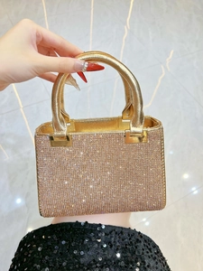 Detailed view of the sparkling gold rhinestone evening clutch with round metal handles