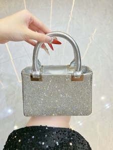Close-up of sparkling silver rhinestone handbag with metallic handle and crystal details