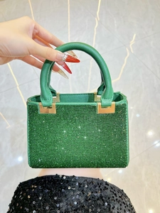 Detailed close-up of emerald green rhinestone evening bag with elegant metallic accents