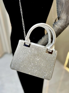 Detailed macro view of the sparkling silver rhinestone evening bag and its metallic chain