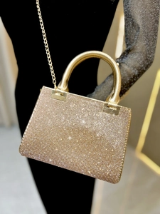 Detailed view of luxury gold rhinestone evening bag with elegant metal handle and chain