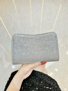 Macro view of silver sequined clutch bag with sparkling texture and hard shell design
