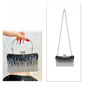 Macro view of luxury rhinestone clutch showing metal ring handle and detachable chain strap