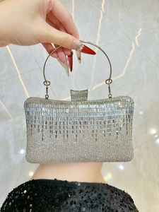 Detailed close-up of silver rhinestone evening bag with elegant fringe crystal accents