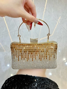 Macro view of luxurious evening clutch featuring gradient rhinestones and gold metal ring handle