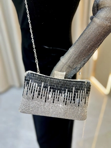 Detail of evening clutch featuring gradient rhinestones and silver metal chain strap