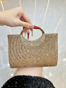 Close-up of sparkling rhinestone evening bag with gold circular handle and secure closure