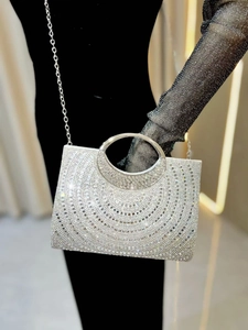 Detailed close-up of sparkling silver evening clutch bag with radiating rhinestone patterns