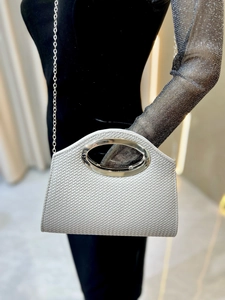 Detail of silver woven texture handbag with metal oval handle and chain strap