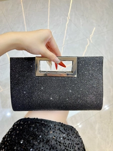 Detail of glitter evening clutch featuring rectangular silver metal hollow handle