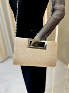Detail of champagne gold glitter evening bag with metallic handle and chain strap