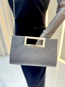 Detail of silver sequin evening clutch with metal handle and elegant chain strap