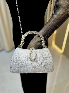 Macro shot of silver evening clutch bag with high-shine rhinestones and chain strap