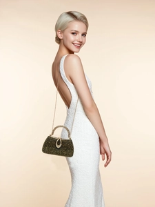 Elegant woman in white lace dress holding a luxury black evening bag with gold rhinestones