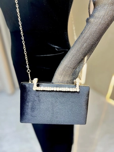 Détail de la pochette de soirée en velours noir avec poignée en strass et chaîne