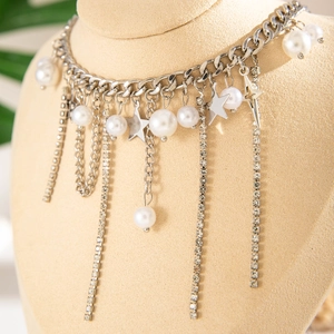 Dettaglio della collana con nappine d'argento, perle e stelle su busto di gioielli