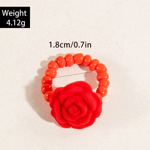 Detail eines roten Harzrosenrings mit lebhaften orangefarbenen Perlen und Blumendesign