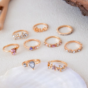 Set di 9 anelli placcati in oro con motivi floreali, strass e perle artificiali