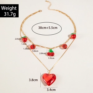 Detailed size view of red acrylic heart and fruit pendants on double-layered gold chain