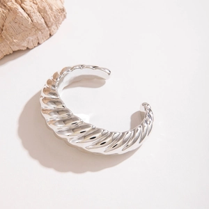 Vue détaillée du bracelet jonc ouvert argenté avec texture spirale et fini poli miroir
