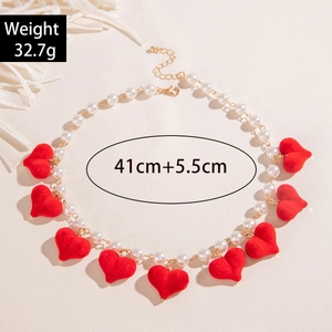 Macro shot of 9 red flocked heart pendants on a white pearl strand necklace for women