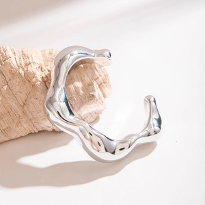 Gros plan détaillé du bracelet manchette argenté ondulé avec finition miroir liquide