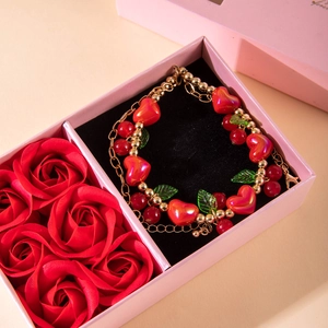 Red heart bracelet in a pink gift box with decorative roses for Valentines Day