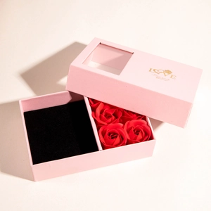 Pink gift box with four red soap roses and jewelry compartment with gold Love print