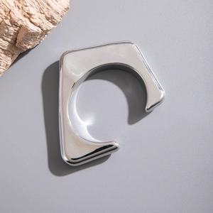 Gros plan détaillé d'un bracelet manchette géométrique argenté avec finition miroir