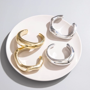 Vue détaillée de quatre joncs CCB minimalistes en finitions miroir dorée et argentée
