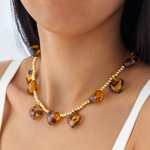 Detail of gold beaded necklace with heart-shaped amber tortoiseshell resin pendants