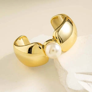 Vue détaillée d'un large bracelet manchette plaqué or orné d'une grande perle blanche