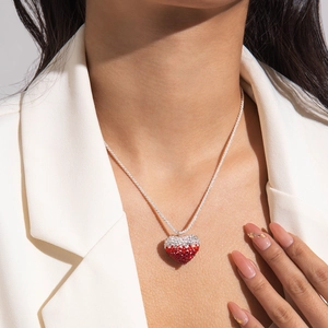 Detailed view of a silver necklace with a sparkling red and white gradient crystal heart