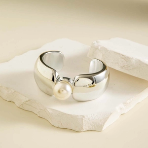 Détail du bracelet manchette argenté avec perle centrale sur socle en pierre