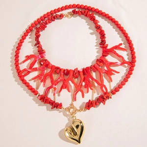 Multi-layered necklace with red beads, coral-like resin accents and a large gold heart pendant