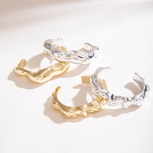 Lot de quatre bracelets ouverts or et argent au design texturé de métal liquide