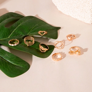 Detailed close-up of 8pcs gold alloy ring set featuring hollow hearts and bow designs