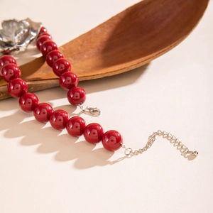 Retro red beaded necklace featuring a metallic rose flower pendant and lobster clasp