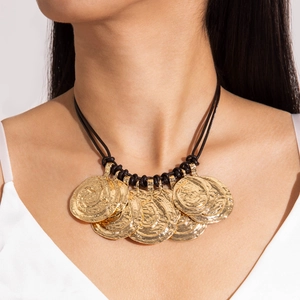 Close-up of gold layered coin pendants with vintage hammered texture on black cord