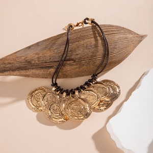 Macro detail of retro gold alloy hammered flower pendants on a bohemian beaded necklace
