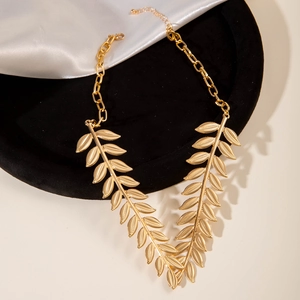 Detailed view of golden leaf-shaped metal necklace on premium black velvet stand