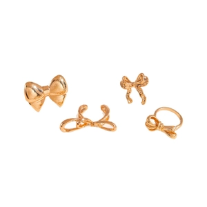 Golden bow jewelry set featuring ring and ear clips on a clean white background