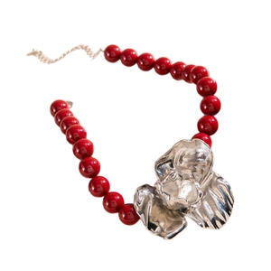 Retro chunky red bead necklace with large silver alloy 3D flower pendant on white background