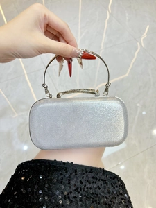 Close-up of silver glitter evening clutch bag with rhinestone handle and metal ring