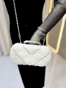 Detail view of the intricate pearl daisy patterns and sparkling rhinestones on the evening bag