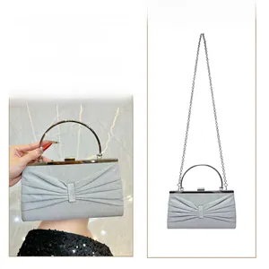 Detail of silver glitter evening bag with pleats, metal handle and crossbody chain