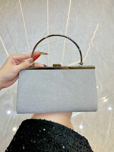 Detail of silver glitter evening clutch bag with round gold metal handle for parties