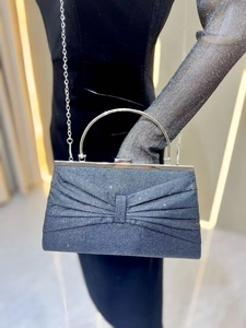 Detail of dark blue glitter evening bag with bow pleats and silver metal handle