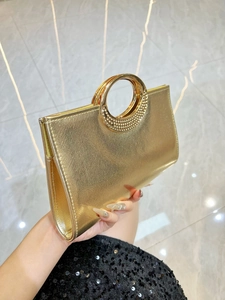 Elegant gold evening clutch bag with dual circular metal handles and textured finish