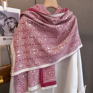 Detail view of burgundy and cream geometric triangle pattern scarf with soft fringe trim